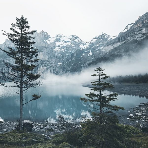A New Day Dawns Le brouillard descend sue l'Deux pêcheurs sur une barque au milieu du lac Oeschinensee en Suisse