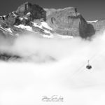 Une cabine téléphérique descend dans le brouillard dans les Alpes Suisses